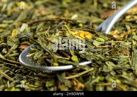 Sécher les feuilles de thé vert avec du chanvre et de la rose.Mélange de bien-être à base de plantes sur une surface en bois rustique.Macro Banque D'Images