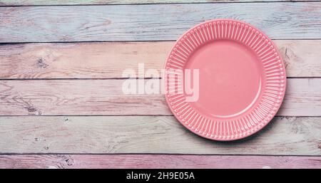 Assiette rose vide sur fond en bois pastel Banque D'Images