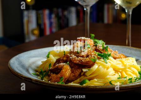 Fettuccine italienne alfredo avec crevettes cajun servi avec du vin blanc de pinot grigio Banque D'Images