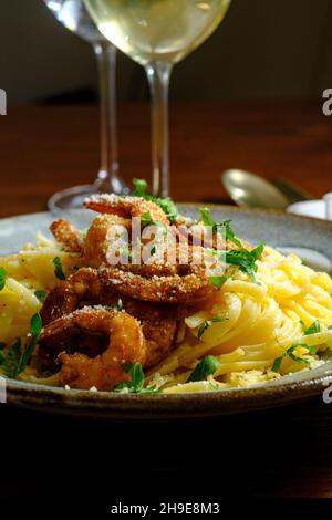 Fettuccine italienne alfredo avec crevettes cajun servi avec du vin blanc de pinot grigio Banque D'Images