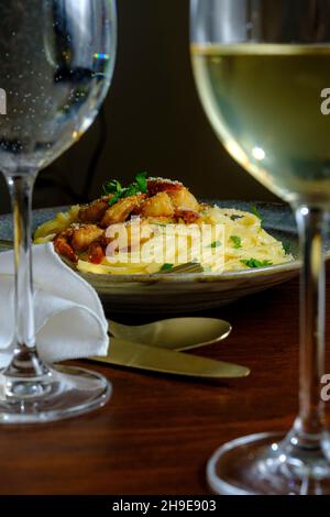 Fettuccine italienne alfredo avec crevettes cajun servi avec du vin blanc de pinot grigio Banque D'Images