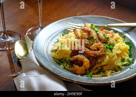 Fettuccine italienne alfredo avec crevettes cajun servi avec du vin blanc de pinot grigio Banque D'Images