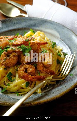 Fettuccine italienne alfredo avec crevettes cajun servi avec du vin blanc de pinot grigio Banque D'Images