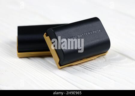 KHARKOV, UKRAINE - 14 MARS 2021 : batteries Kastar au lithium-ion ou au lithium-ion pour photocameras DSLR modernes sur table en bois blanc Banque D'Images