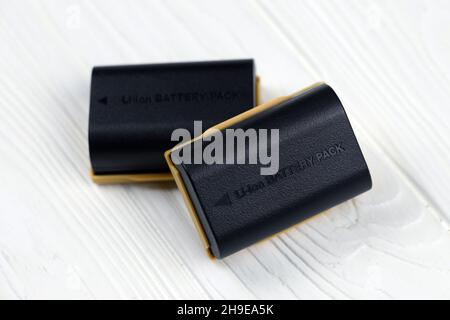 KHARKOV, UKRAINE - 14 MARS 2021 : batteries Kastar au lithium-ion ou au lithium-ion pour photocameras DSLR modernes sur table en bois blanc Banque D'Images