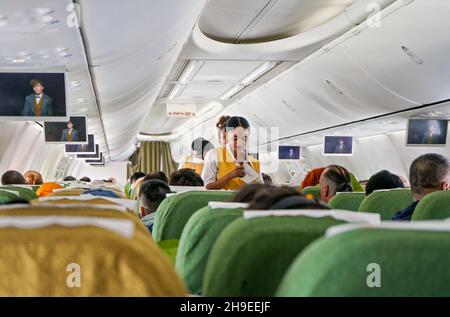 Addis-Abeba, Éthiopie - 23 avril 2019 : intérieur d'un avion commercial pendant le vol, passagers assis, compartiments à bagages fermés, femmes africaines assistés Banque D'Images