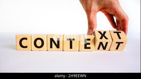 Symbole de contenu et de contexte.Homme d'affaires tourne des cubes en bois et change le mot contexte en contenu.Belle table blanche, fond blanc.Entreprise Banque D'Images