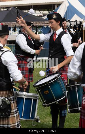 Un batteur d'un groupe de tubes écossais des Highlands fleurit ou tord ses pilons tout en jouant à un festival écossais dans l'Utah. Banque D'Images