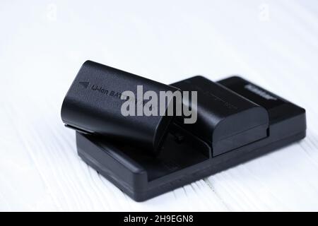 KHARKOV, UKRAINE - 14 MARS 2021 : batteries Kastar au lithium-ion ou au lithium-ion pour photocameras DSLR modernes sur table en bois blanc Banque D'Images