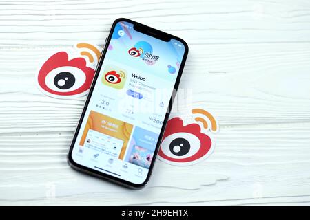 KHARKOV, UKRAINE - 5 MARS 2021: Sina Weibo icône et application de l'App Store sur iPhone 12 pro écran d'affichage sur table blanche en bois Banque D'Images