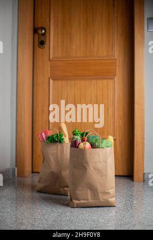 Des sacs de shopping de nourriture sont à la porte de la maison ou de l'appartement.Livraison de légumes et de fruits pendant la quarantaine et l'auto-isolement Banque D'Images