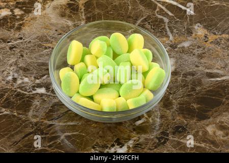 Sucrerie jaune et vert aigre tutti frutti dans un bol en verre Banque D'Images