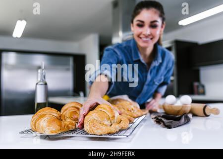 Jeune femme latine qui cuit des ingrédients de croissant dans la cuisine au Mexique en Amérique latine Banque D'Images