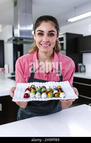 latino jeune femme pâtissière préparant de délicieux bonbons chocolats dans la cuisine au Mexique Amérique latine Banque D'Images