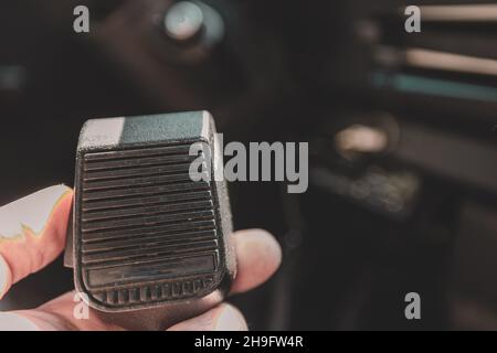 Microphone CB tenu à la main dans une camionnette ou un camion pour la communication à la volée.Récepteur radio et microphone à bande citoyenne. Banque D'Images