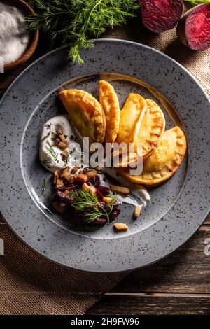 Tartes aux pommes de terre maison cuites au four, sauce crémeuse à l'ail, betteraves cuites au four et bacon rôti - Haut de la vue. Banque D'Images