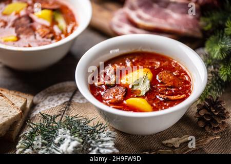 Soupe aigre traditionnelle de noël avec pommes de terre, saucisses, porc fumé et champignons. Banque D'Images