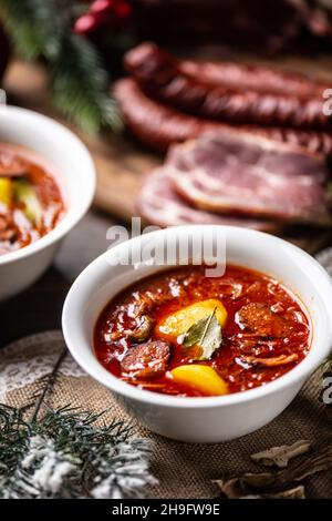 Soupe aigre traditionnelle de noël avec pommes de terre, saucisses, porc fumé et champignons. Banque D'Images