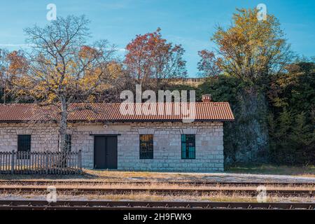 Entrepôt de marchandises ou ancien bâtiment de service sur la gare de Stanjel.Trains visibles à l'avant. Banque D'Images