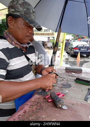 Photo éditoriale, Indonésie, Djakarta orientale, Kramat Jati, 12 décembre 2021,Homme en réparation ou en remplacement de la montre à bracelet du client Banque D'Images