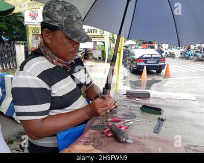 Photo éditoriale, Indonésie, Djakarta orientale, Kramat Jati, 12 décembre 2021,Homme en réparation ou en remplacement de la montre à bracelet du client Banque D'Images