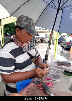 Photo éditoriale, Indonésie, Djakarta orientale, Kramat Jati, 12 décembre 2021,Homme en réparation ou en remplacement de la montre à bracelet du client Banque D'Images