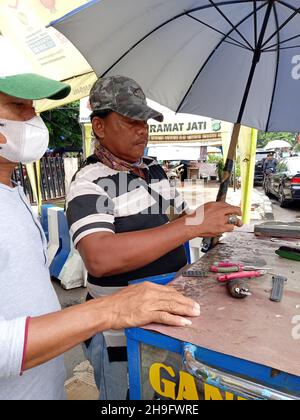 Photo éditoriale, Indonésie, Djakarta orientale, Kramat Jati, 12 décembre 2021,Homme en réparation ou en remplacement de la montre à bracelet du client Banque D'Images