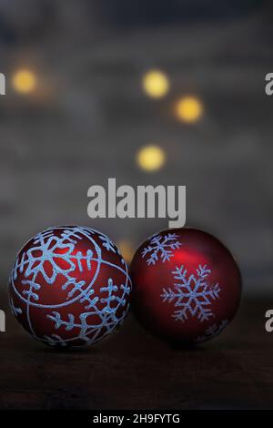 gros plan de deux boules de noël scintillantes rouges sur fond sombre Banque D'Images