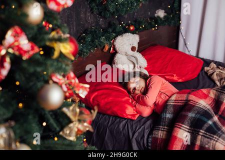 Une petite fille dans la chambre dort à l'arbre de Noël nouvel an Banque D'Images