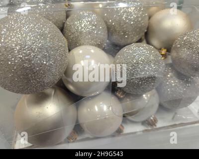 Boules de Noël argentées dans une boîte en plastique transparent. Fond brillant étincelant pour la nouvelle année. Banque D'Images
