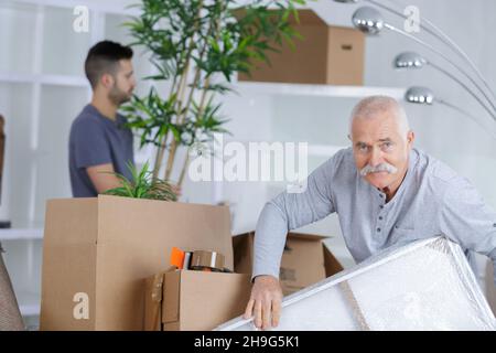 homme d'âge moyen travaillant à l'agence de relocalisation Banque D'Images