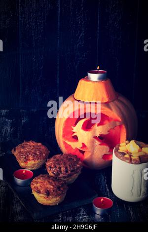 composition d'automne avec citrouille sculptée, boisson chaude piquante à la citrouille et muffins Banque D'Images