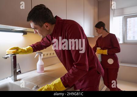 Deux nettoyants en uniforme désinfecte les surfaces de la cuisine Banque D'Images