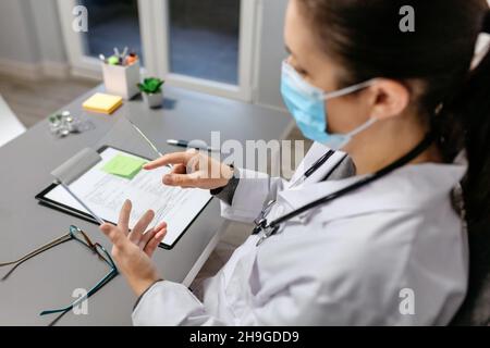Femme médecin travaillant avec une tablette transparente dans son bureau Banque D'Images