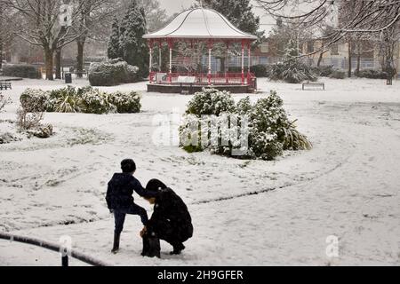 Neige d'hiver au Denton Victoria Park à Tameside avec son kiosque Edwardian classé Grade II et son mémorial de guerre de WW1 Banque D'Images