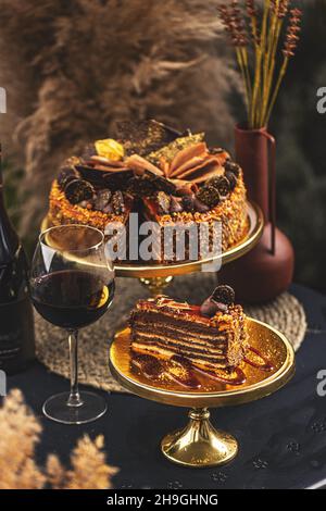 Gâteau de Dobos sur un stand servi avec un verre de vin Banque D'Images