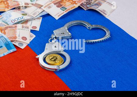 pile de papier russe roubles monnaie et tibicoin tiragé avec menottes sur fond de drapeau russe - crypto interdiction de la loi concept Banque D'Images