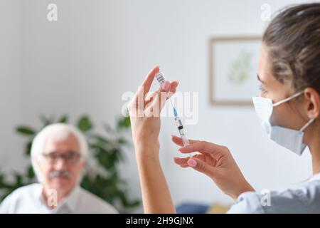 Gros plan de l'infirmière tenant la seringue dans ses mains et préparant un vaccin pour le patient à l'hôpital Banque D'Images