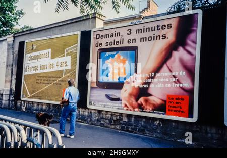 Paris, France, personne marchant près des affiches du SIDA sur l'affichage, publicités françaises, sur la rue, aides 1990s, affiches de panneaux d'affichage vintage, publicité contemporaine Banque D'Images