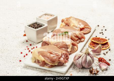 Cuisse de poulet crue sans os ni peau.Un ingrédient utile pour préparer des aliments sains, des épices, de l'ail.Arrière-plan léger, espace de copie Banque D'Images