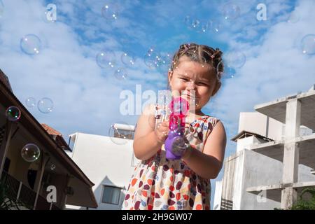 L'enfant souffle des bulles.Fille jouant avec le pistolet Bubbles Banque D'Images