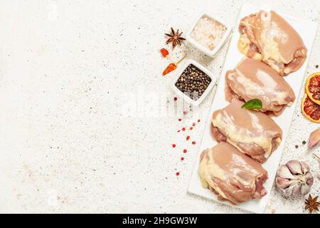 Cuisse de poulet crue sans os ni peau.Un ingrédient utile pour préparer des aliments sains, des épices, de l'ail.Arrière-plan léger, vue de dessus Banque D'Images