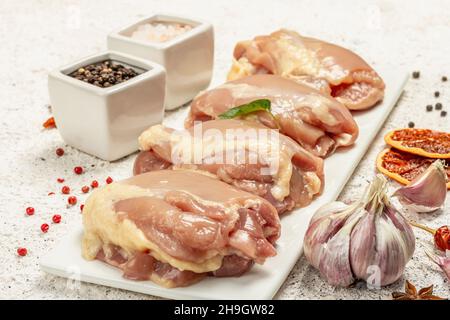 Cuisse de poulet crue sans os ni peau.Un ingrédient utile pour préparer des aliments sains, des épices, de l'ail.Arrière-plan léger, gros plan Banque D'Images