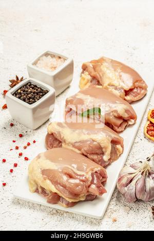 Cuisse de poulet crue sans os ni peau.Un ingrédient utile pour préparer des aliments sains, des épices, de l'ail.Arrière-plan léger, gros plan Banque D'Images