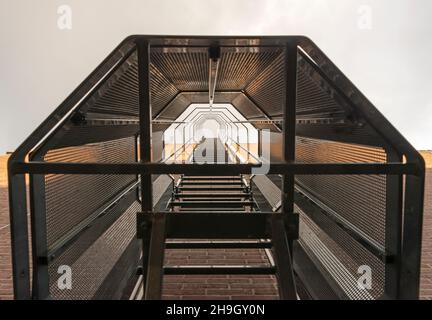 vue de bas en haut d'un escalier avec une cage attachée à un immeuble d'appartements Banque D'Images