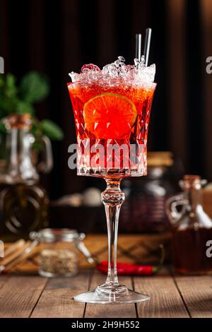 Cocktail sucré d'alcool aux baies rouges dans un verre de fantaisie Banque D'Images