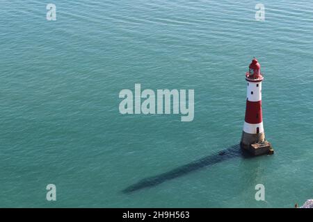 Phare de Beachy Head - Tour de roche traditionnelle rouge et blanche - vue en mer en jetant une ombre au soleil de midi (Seven Sisters Cliffs, Sussex, Angleterre) Banque D'Images