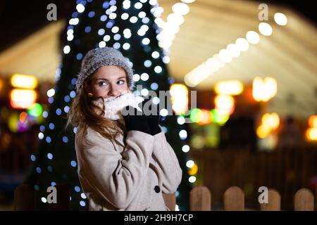 Portrait d'un adolescent souriant portant des vêtements d'hiver à l'extérieur.Se cacher derrière le foulard Banque D'Images