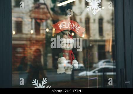 Décoration de Noël à la porte du café avec l'inscription Bienvenue.Célébrez Noël, le nouvel an et le concept de fête. Banque D'Images