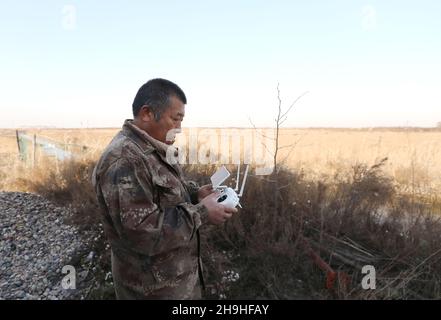 (211207) -- SHIJIAZHUANG, 7 décembre 2021 (Xinhua) -- Tian Zhiwei, un protecteur d'oiseaux sauvages, observe les oiseaux à proximité avec un drone dans la zone humide de Daqinghe, dans le comté de Laoing, dans la province de Hebei, au nord de la Chine, 7 décembre 2021.Chaque année, des millions d'oiseaux migrateurs affluent dans le comté de Laoing pendant leur migration.Tian Zhiwei, 52 ans, se consacre aux activités de protection et de sauvetage des oiseaux sauvages depuis 2004.En 2011, il établit une station de sauvetage dans le comté de Laoting.Avec une superficie de 35 um (environ 5.8 acres), la station de sauvetage a sauvé, adopté et libéré plus de 100 espèces et des dizaines de milliers de sauvages Banque D'Images